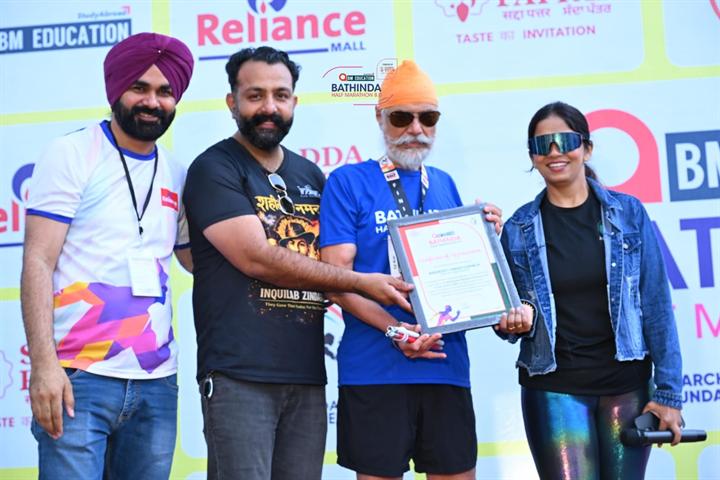 A runner receives his finisher certificate on stage at Bathinda Half Marathon 8.0