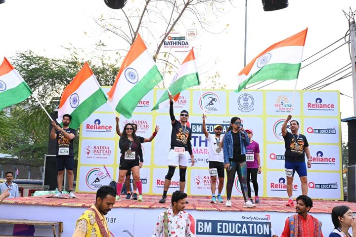 Runners wave Indian flags on stage at Bathinda Half Marathon 8.0