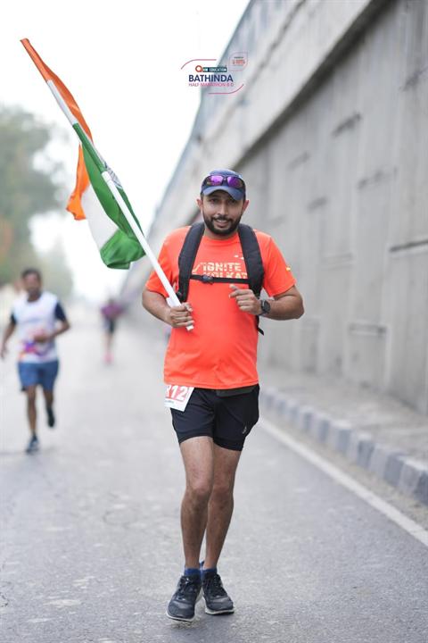 A runner carries the Indian flag on the Bathinda Half Marathon 8.0 course